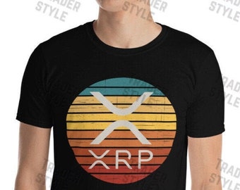 May include: A black t-shirt with a vintage-style graphic of the XRP cryptocurrency logo. The logo is a white X with the letters XRP below it, all set against a colorful sunset background.