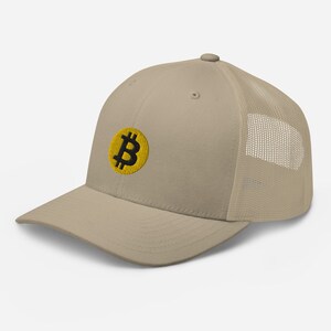 May include: A beige and black baseball cap with a yellow embroidered Bitcoin logo. The cap has a mesh back.