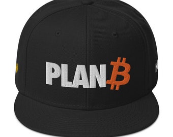 May include: Black flat-brimmed baseball cap with the text "PLAN B" embroidered in white and an orange Bitcoin symbol. The cap has a structured fit and a curved brim. A small yellow detail is visible on the side.