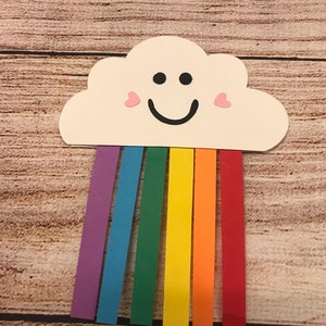 May include: A white paper cloud with a smiling face and pink hearts for cheeks, with a rainbow of coloured paper strips hanging from the bottom.