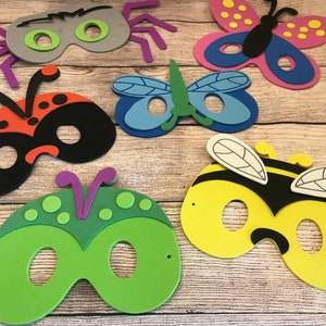 Peut inclure: Cinq masques d'insectes en mousse color&eacute;s pour enfants. Les masques sont en forme d'araign&eacute;e, de coccinelle, de libellule, d'abeille et de papillon. Les masques ont des trous pour les yeux et sont d&eacute;cor&eacute;s de d&eacute;tails comme des points, des rayures et des ailes.