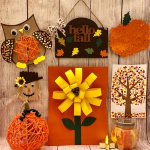 May include: Fall-themed craft decorations including an owl with sequins, a yarn pumpkin, a scarecrow, a paper flower, a tree made of colorful circles, and a sign that says "hello fall".