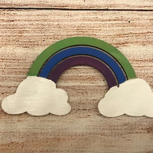 May include: Wooden rainbow with three layers of colour: green, blue, and purple. The rainbow is attached to two white wooden clouds.