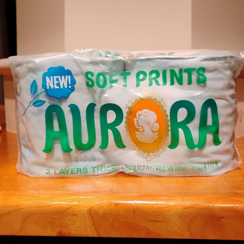 May include: A package of Aurora brand soft print tissues. The package is clear plastic, with the words "NEW! SOFT PRINTS AURORA" in green. The package contains two rolls of 2-ply tissues.