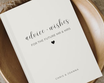 Peut inclure: Livre blanc avec le texte "advice + wishes for the future Mr. & Mrs. Chris & Joanna" et un petit cœur noir.