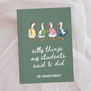 Op de afbeelding: Een groen notitieboek met de tekst "silly things my students said & did" en "SO I NEVER FORGET." De kaft toont cartoon ganzen met outfits. Eén gans draagt een roze strik, een andere draagt een overall.