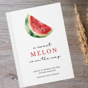 Puede incluir: Un libro blanco con una ilustración de una rodaja de sandía. El texto dice "a sweet MELON is on the way" en rojo y negro. También incluye "ADVICE & WISHES FOR THE FUTURE PARENTS HANNAH AND JACKSON".