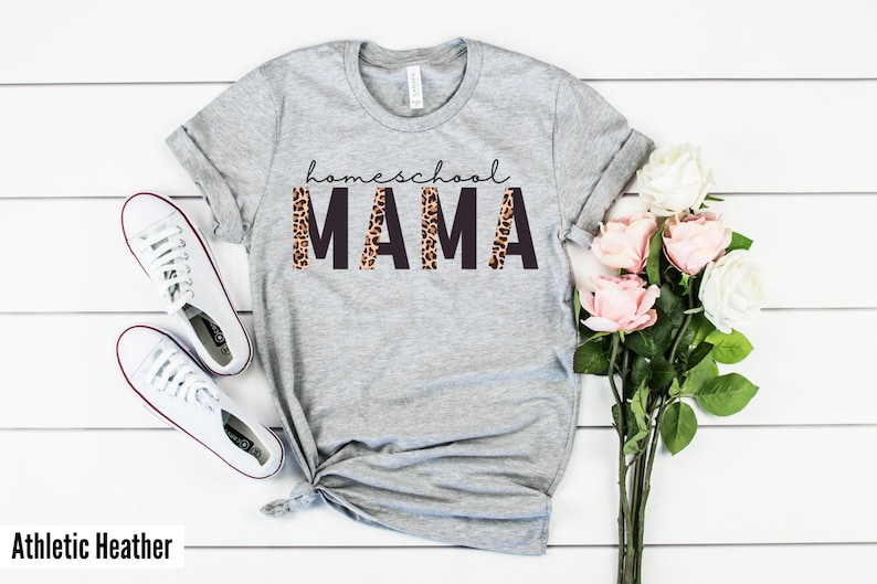 Op de afbeelding: Grijs T-shirt met de tekst "homeschool MAMA" in zwarte letters met een luipaardprint.