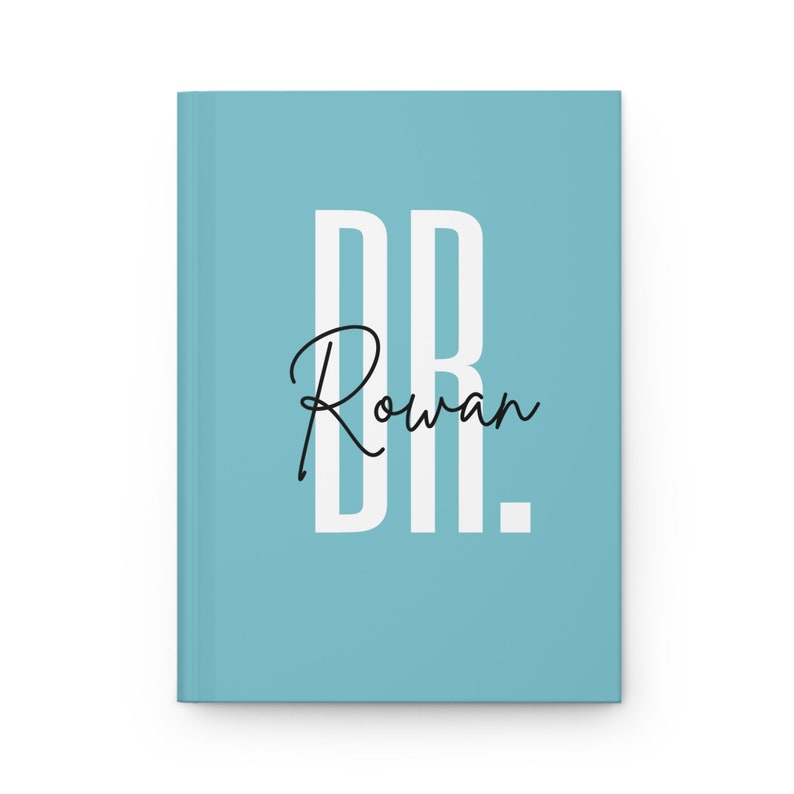May include: A light blue journal with the text "DR. Rowan" in white and black. The journal is closed and has a clean, minimalist design. The cover is a solid light blue color.