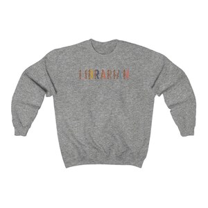 Peut inclure: Un sweat-shirt gris avec le mot "LURARIN" imprim&eacute; sur le devant en lettres color&eacute;es avec un motif l&eacute;opard.