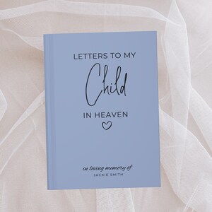 May include: A light blue journal with the text "Letters to My Child in Heaven" and a small heart symbol. The text "in loving memory of JACKIE SMITH" is at the bottom of the journal.