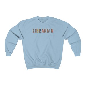 Peut inclure: Sweat-shirt bleu clair avec le mot "LIBRARIAN" imprim&eacute; en lettres color&eacute;es avec un motif l&eacute;opard.