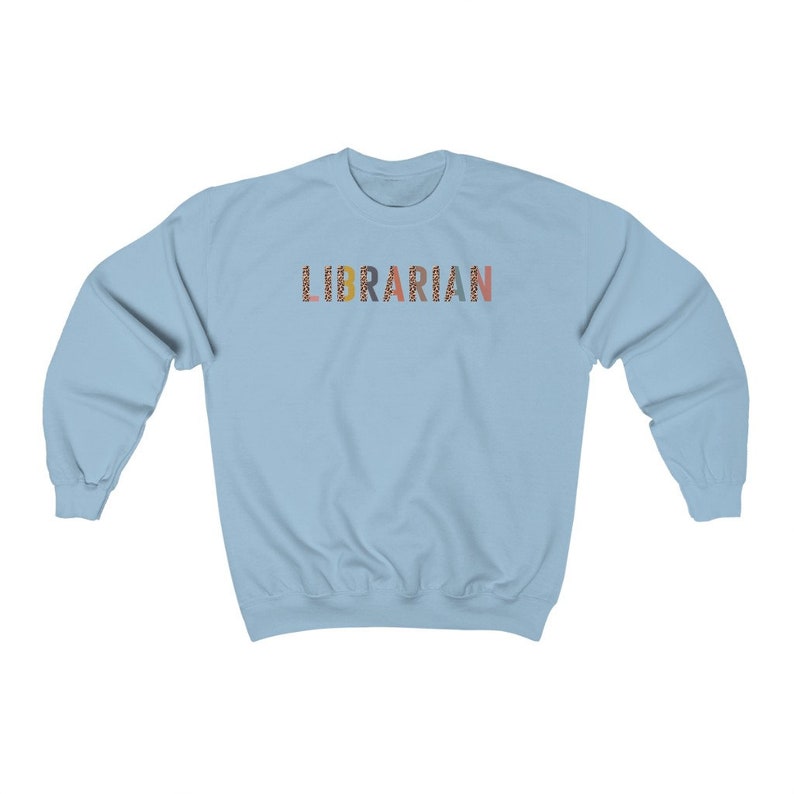 Peut inclure: Sweat-shirt bleu clair avec le mot "LIBRARIAN" imprim&eacute; en lettres color&eacute;es avec un motif l&eacute;opard.