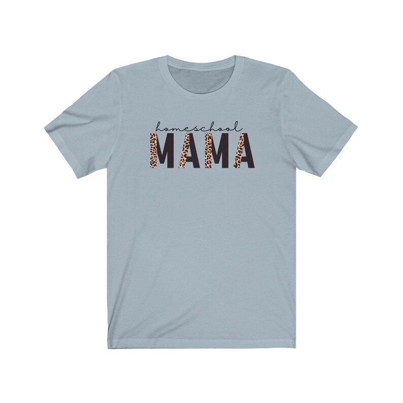 Op de afbeelding: Lichtblauw T-shirt met de tekst "homeschool MAMA" in zwarte letters. Het woord "MAMA" is bedrukt met een luipaardprint.