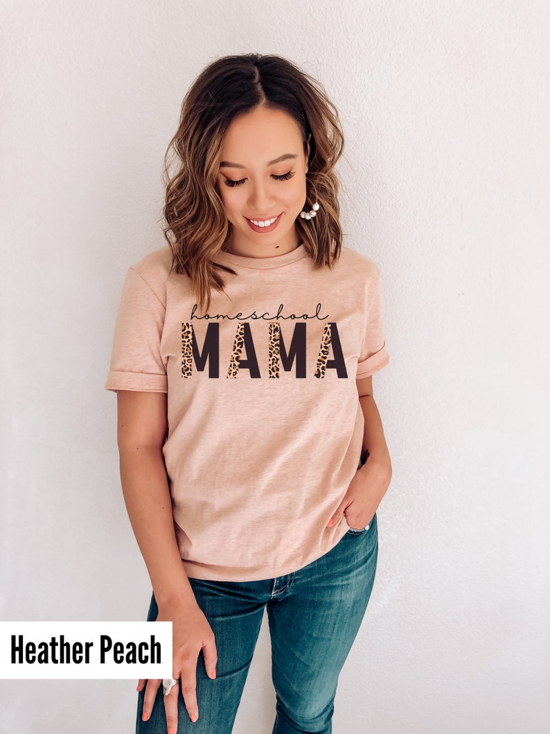 Op de afbeelding: Een heideperzikkleurig T-shirt met de tekst "homeschool MAMA" in zwart met een luipaardprint.