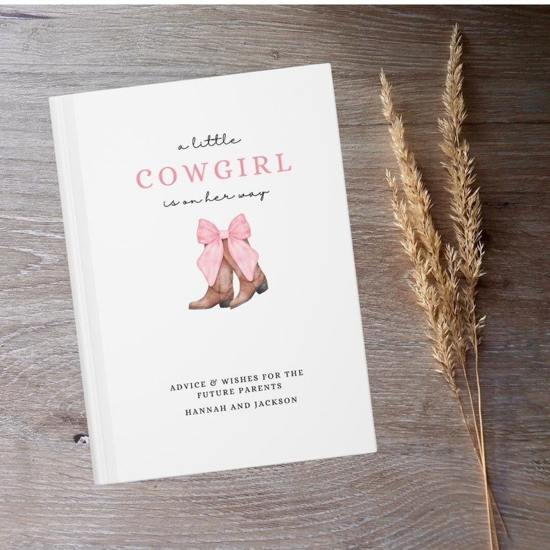Puede incluir: Un libro blanco con el texto "a little COWGIRL is on her way" en letras rosas y negras. Hay un dibujo de un par de botas de vaquero marrones con lazos rosas. El texto "ADVICE & WISHES FOR THE FUTURE PARENTS HANNAH AND JACKSON" est&aacute; en la parte inferior del libro.