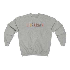 Peut inclure: Un sweat-shirt gris avec le mot "LIBRARIAN" imprim&eacute; sur le devant en lettres color&eacute;es avec un motif l&eacute;opard.