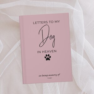 Peut inclure: Un journal rose avec le texte "Lettres &agrave; mon chien au paradis" et une empreinte de patte. Le journal porte le texte "en souvenir affectueux de TOBY" en bas.