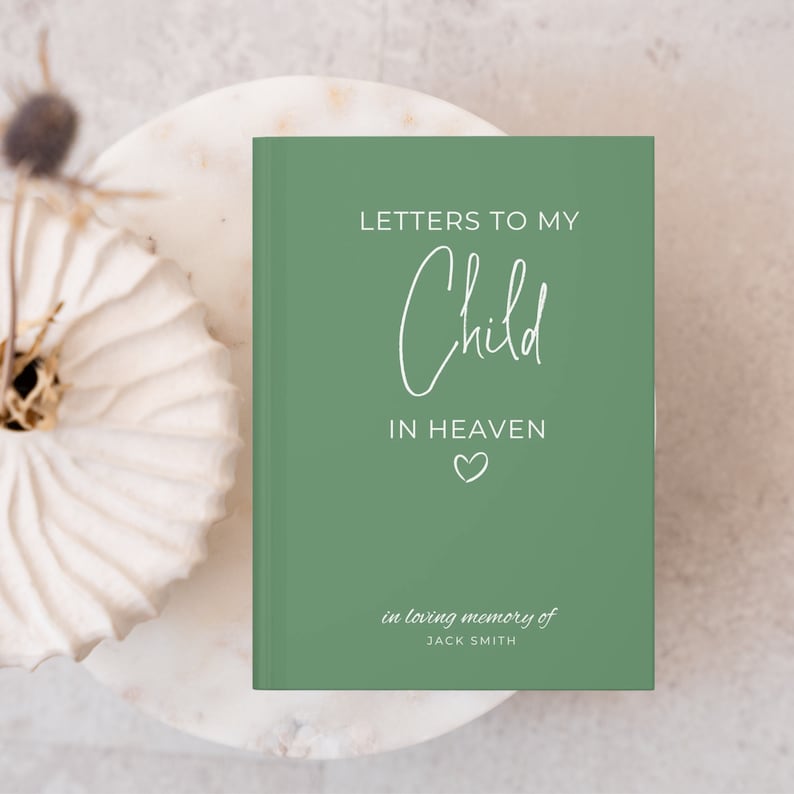 May include: A green journal with the text "Letters to My Child in Heaven" and a small heart symbol. The text "in loving memory of JACK SMITH" is at the bottom of the journal.
