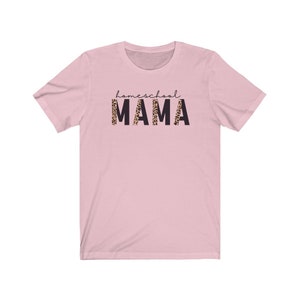 Op de afbeelding: Roze T-shirt met korte mouwen met de tekst "homeschool MAMA" in zwarte letters. Het woord "MAMA" is gedrukt in een luipaardprint.