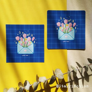 Puede incluir: Dos tarjetas azules y blancas con un patr&oacute;n a cuadros. Cada tarjeta presenta un sobre blanco con flores rosas y purpurina dorada. El texto "with love" est&aacute; escrito en cada tarjeta.