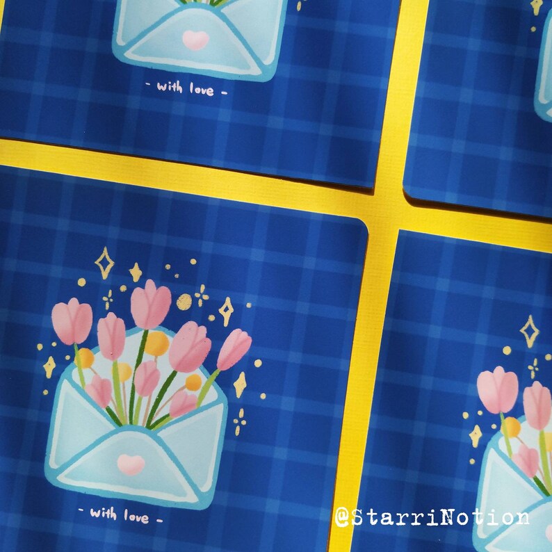 Puede incluir: Un sobre azul y blanco con un coraz&oacute;n rosa y un ramo de flores rosas con purpurina dorada sobre un fondo a cuadros azul y blanco. El texto "with love" est&aacute; escrito debajo del sobre.