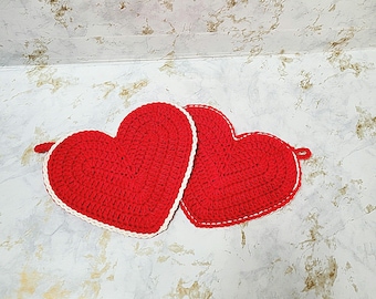 May include: Two red crocheted heart-shaped pot holders with white trim.