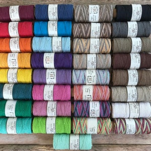 Puede incluir: Una colecci&oacute;n de 24 carretes de cuerda de c&aacute;&ntilde;amo en varios colores y patrones, incluyendo natural, rojo, azul, verde, amarillo y marr&oacute;n. Cada carrete est&aacute; etiquetado con "Hemp Cord" y tiene un patr&oacute;n diferente.