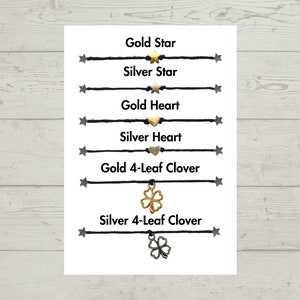 Puede incluir: Una tarjeta blanca con pulseras de cuerda negra con diferentes dijes. Los dijes incluyen estrellas doradas y plateadas, corazones y tr&eacute;boles de cuatro hojas. El texto en la tarjeta dice "Gold Star", "Silver Star", "Gold Heart", "Silver Heart", "Gold 4-Leaf Clover" y "Silver 4-Leaf Clover".