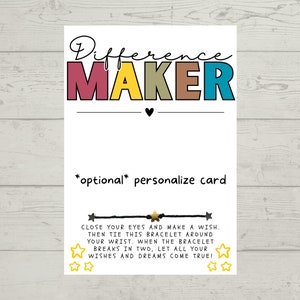 Puede incluir: Una tarjeta blanca con el texto "Difference Maker" en letras de colores. La tarjeta tambi&eacute;n incluye el texto "*opcional* personalizar la tarjeta" e instrucciones para hacer un deseo con una pulsera.