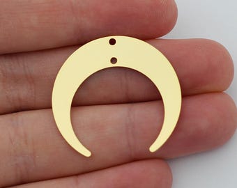 May include: Two gold crescent moon charms with two holes each. The charms are made of metal and have a shiny finish.