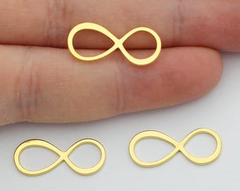 Könnte beinhalten: Drei goldene Unendlichkeits-Anhänger, gezeigt auf einer Hand. Die Anhänger sind klein und zart.