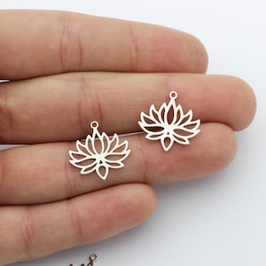 May include: Silver metal lotus flower charms with a hole at the top for attaching to jewelry or other crafts.