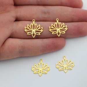 May include: Four gold-colored metal lotus flower charms with a loop at the top for attaching to jewelry or other crafts.