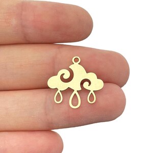 Peut inclure: Breloque en métal doré en forme de nuage avec trois gouttes de pluie qui pendent.