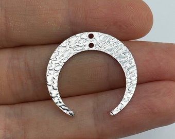May include: Silver crescent moon charm with a hammered texture and two holes for attaching jewelry findings.