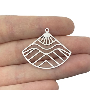 May include: Silver charm featuring a geometric design of waves and mountains. The charm has a hole at the top for attaching to a necklace or bracelet.