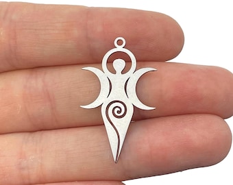 May include: A silver-toned metal pendant featuring a stylized figure with a circular head, crescent moon shapes on either side, and a spiral design at the base. The pendant includes a small loop at the top for attachment to a chain or cord.