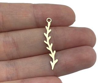 May include: A gold-colored metal charm shaped like a slender, curved branch or vine with small, alternating leaf-like protrusions along its length and a small circular loop at the top for attachment, presented against a plain white background.