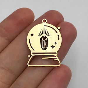 May include: Gold metal charm shaped like a snow globe with a crystal inside and stars around it.