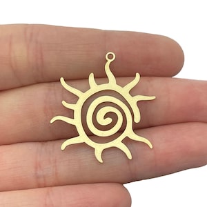 May include: Gold-coloured metal charm shaped like a sun with a spiral design in the centre. The charm has a small loop at the top for attaching to jewellery.