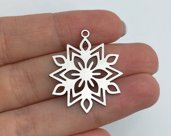 Op de afbeelding: Zilveren sneeuwvlok charme met een delicaat, ingewikkeld ontwerp. De charme heeft een lus aan de bovenkant om te bevestigen aan sieraden of andere knutselwerkjes.