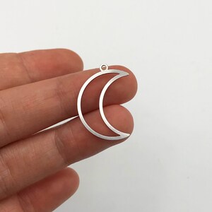 Puede incluir: Encanto de luna creciente de plata con un agujero en la parte superior para sujetarlo a joyas u otras manualidades.
