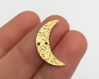 May include: Gold crescent moon charm with a textured surface and two holes.