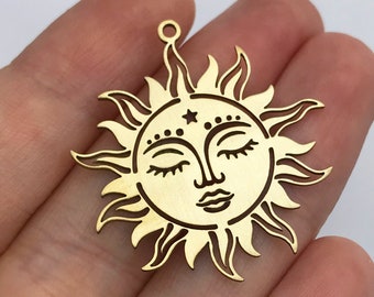 May include: Gold-toned metal charm featuring a sun with a closed-eye face and a star above it.