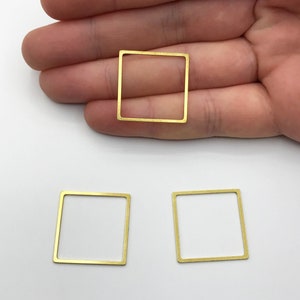May include: Three gold-coloured metal square frames. The frames are hollow and have a smooth, polished finish.