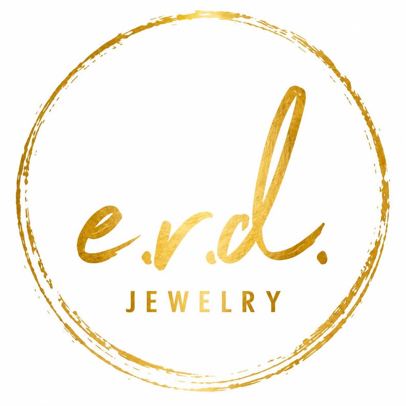 Op de afbeelding: Een cirkelvormig logo met een gestructureerde gouden penseelstreekrand. Binnenin de cirkel staan de kleine letters e.r.d. in een gouden scriptlettertype, met het woord JEWELRY in gouden hoofdletters direct onder de letters.