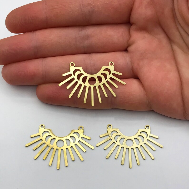 May include: Three gold metal sunburst pendant charms with a geometric design. Each charm has two jump rings for attaching to jewelry.