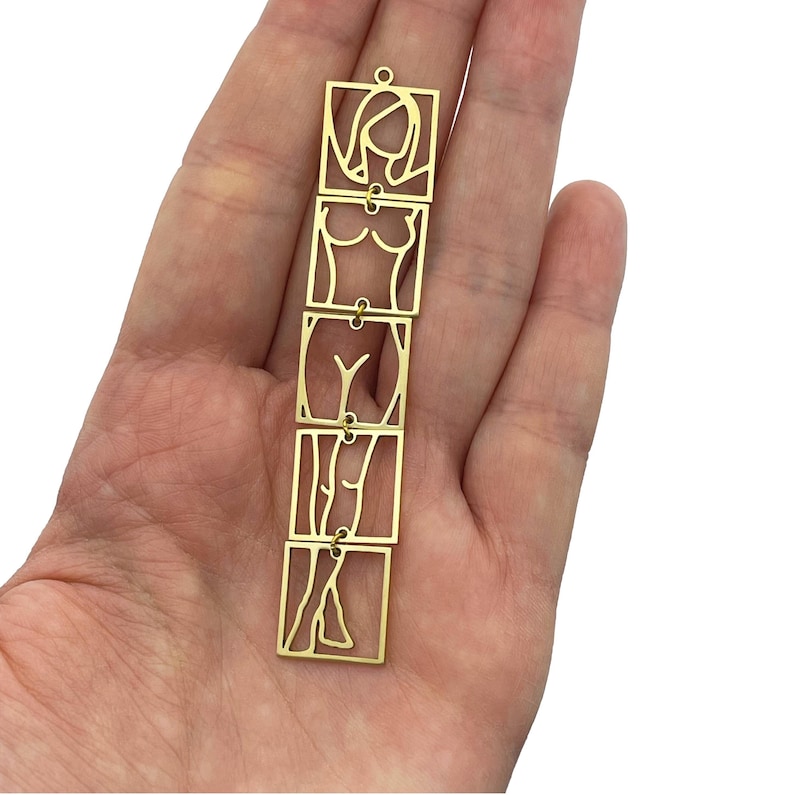 May include: A gold-colored metal chain with four square links. Each link features a cutout design of a female figure in different poses, from head to toe.