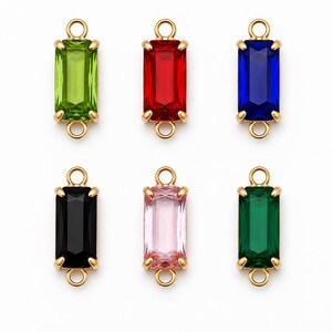 Può includere: Sei connettori rettangolari in pietra preziosa disposti su due file. Ogni pezzo presenta una pietra sfaccettata color verde lime, rosso, blu, nero, rosa chiaro o verde scuro, incastonata in una montatura in metallo dorato con un occhiello.